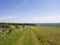 Scenic English landscape with a grassy farm track and bean fields