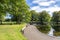 Scenic footpath with benches around a small shallow pond in Duthie Park, Aberdeen