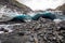 Scenic glacier ice caves with river flowing out from inside