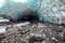 Scenic glacier ice caves with river flowing out from inside