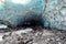 Scenic glacier ice caves with river flowing out from inside
