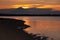 Scenic golden sea sunset with dark volcano in distance island with colorful orange heaven reflection in water, high contrast.