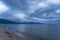Scenic gray-blue clouds during sunrise over coastline with sandy beach and clear sea water in Alcamo Marina, small town in Sicily