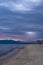 Scenic gray-blue clouds during sunrise over coastline with sandy beach and clear sea water in Alcamo Marina, small town in Sicily