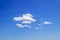 Scenic group of white fluffy cumulus clouds high in the blue summer sky. Different cloud types and atmospheric phenomena. Skyscape