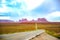 The scenic highway of U.S. Route 163 in Utah leading south to Arizona, through the red rocks of Monument Valley, in white cloud