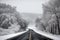 scenic highway in winter, with snow-covered trees and frozen lakes