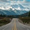 Scenic journey road leads toward majestic snowy mountain vista