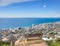 Scenic landscape banner view of a public bench on a cliff or hill overlooking the city and the ocean. Empty, peaceful