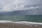 Scenic landscape of the beach and dark blue sea, cloudy sky before a thunderstorm