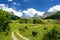 Scenic landscape of mountain valley in european Alps. Road goes into the distance. Stunning view of mountains and valleys in