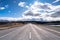 A scenic landscape of road to Aoraki Mount Cook - Lake Pukaki with blue sky and clouds.