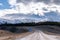 A scenic landscape of road to Aoraki Mount Cook - Lake Pukaki with blue sky and clouds.