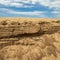 Scenic landscape. Sandy shore. Sand rock. Cloudy sky