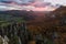 Scenic landscape in Sulov, Slovakia, on beautiful autumn sunrise with colorful leaves on trees in forest and bizarre pointy rocks