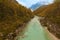 Scenic landscape view of alpine Soca River. Emerald green water flows between mountains with dense forest