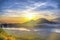 A scenic landscape view of cloud movement during the morning sunrise with golden sunbeam behind the mountain in Bali