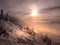 Scenic landscape with a view from a mounatin range to the valley filled with low clouds and fog during temperature inversion