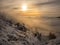 Scenic landscape with a view from a mounatin range to the valley filled with low clouds and fog during temperature inversion