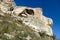 scenic limestone cliff with caves with azure sky background in Crimea