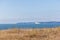 A scenic majestic view of  Bournemouth bay from a grassy cliff under a beautiful blue sky and some white clouds