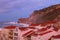 Scenic morning landscape view of storm in Atlantic ocean near Nazare. Big wave breaks about picturesque cliff. Nazare, Portugal.