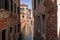 Scenic narrow canal with ancient buildings with potted plants in Venice, Italy