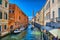 Scenic narrow canal with Carabinieri boats, Venice, Italy, HDR