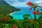 Scenic natural wild landscape with rocky mountains overgrown dense green jungle tree, palm and clear azure water of sea ocean