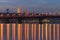 Scenic night cityscape with Paton bridge over Dnieper river. Illuminated Bell tower of Kyiv Pechersk Lavra at the background