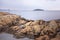 Scenic Oslo Fjord rocky beach, calm water, overcast sky small island. Idyllic landscape with orange rocks on the beach. Norwegian