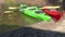 Scenic Panning video Over Two Red and Green colored kayaks stranded on the small beach