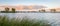 Scenic panorama of colorful clouds over a lake at sunset