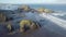 Scenic panoramic aerial drone view of flight above ocean and remote beach in Western USA with rocky cliff coastline and sand beach