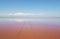 Scenic panoramic view of colorful Pink Salt Lake in Ukraine, blue sky, horizon, copy space.