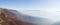 Scenic panoramic view from the mountain Vlasic, a valley filled with fog and peaks above the fog in autumn during a sunny day