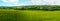 Scenic panoramic view of rolling countryside green farm fields with sheep, cow and green tries in New Grange, County Meath