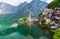 Scenic picture-postcard view of famous Hallstatt mountain village in the Austrian Alps with passenger ship in beautiful morning l