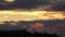 Scenic remote time lapse on moving clouds highlighted by low golden Sun above mountains forest, Scandinavian Mountain range in