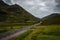 Scenic road crossing the Glen Coe Valley in a stormy day, Scotland, United Kingdom