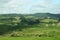 Scenic rural landscape of pastureland, rolling hills and trees on sunny day in Waitomo, New Zealand