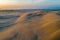 Scenic sand dunes near the ocean at sunrise.