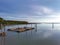 Scenic seascape view of a kelong stage on the sea with mangrove forest and blue sky background. Reflection of branches, wooden kel