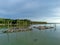 Scenic seascape view of wooden kelong stage on the sea with mangrove forest and blue sky background. Reflection of branches, woode