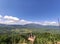 Scenic shot of three people standing at the viewpoint over a green countryside