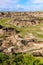 Scenic shot of a valley in Drumheller with a layer of green grass on the eroded surface