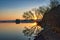 Scenic shot of a waterscape with trees on the side during sunset