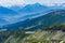 Scenic skyline of snowy mountain tops and green wooded mountainsides