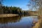 Scenic spring river view in forest with foliage tree leaf and low water with rocks and sand in stream