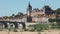 Scenic summer view of Gien townscape overlooking arched bridge across Loire river and medieval Chateau de Gien